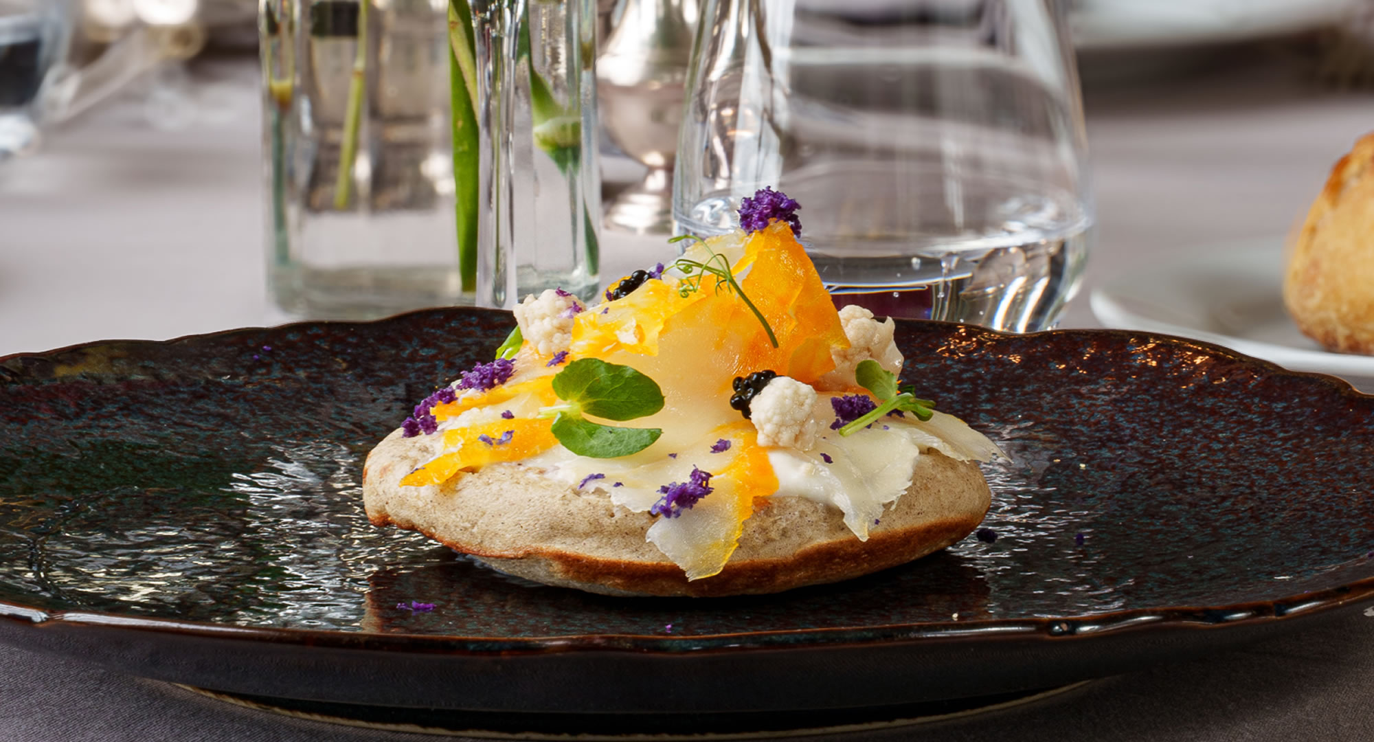 Plat gastronomique élégant sur assiette sombre.