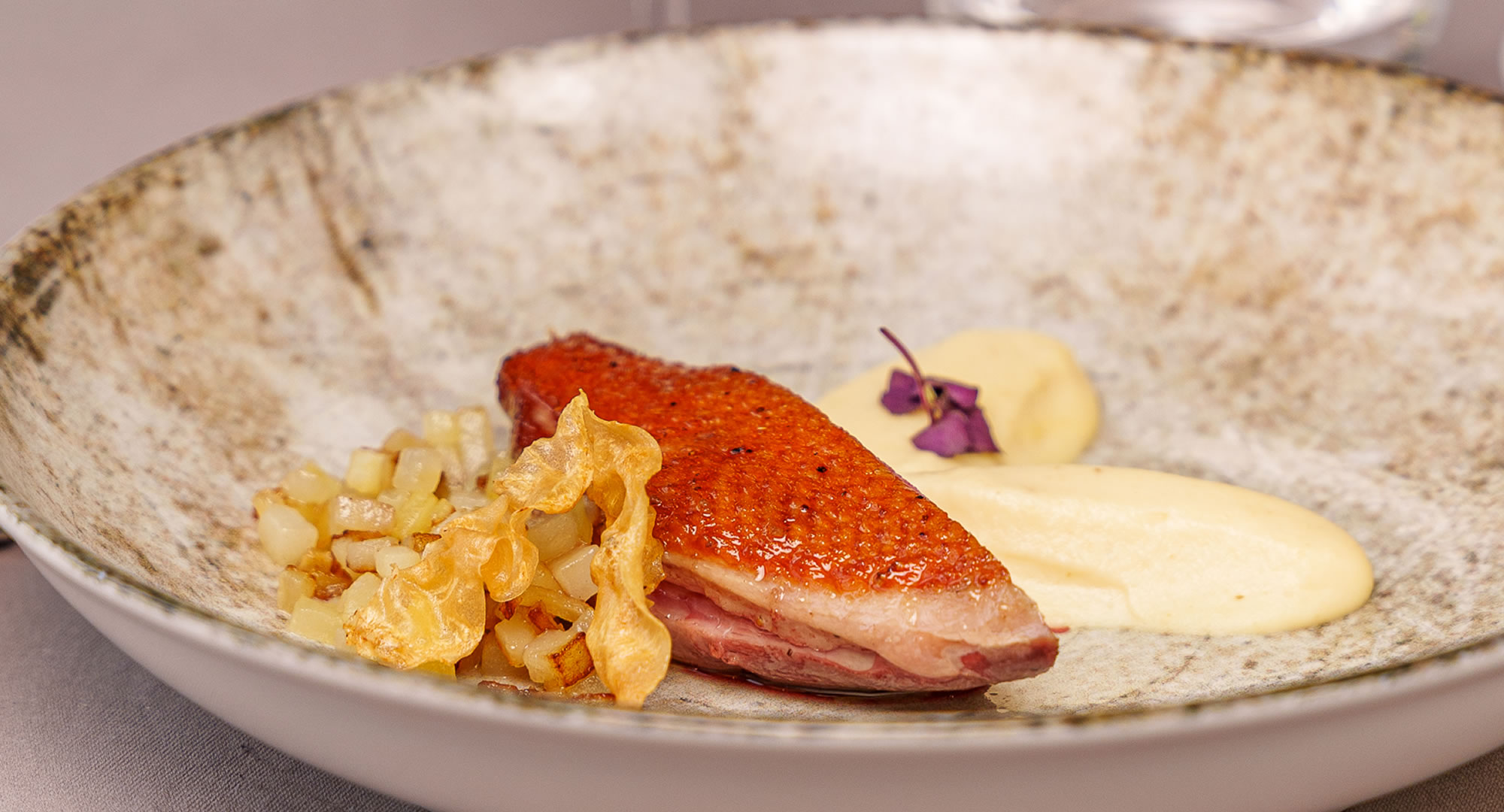 Plat de viande avec purée et légumes décorés.